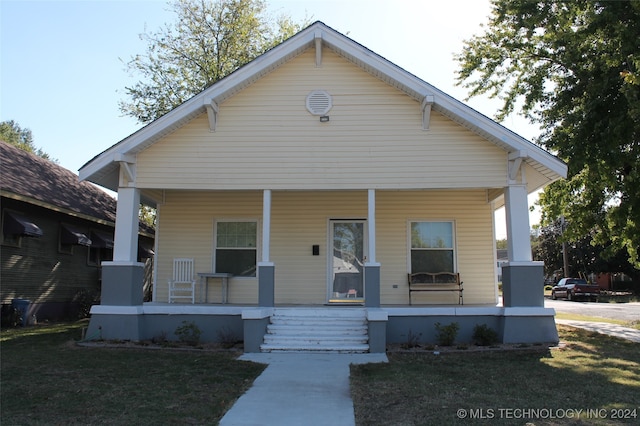 bungalow-style house with a porch and a front lawn