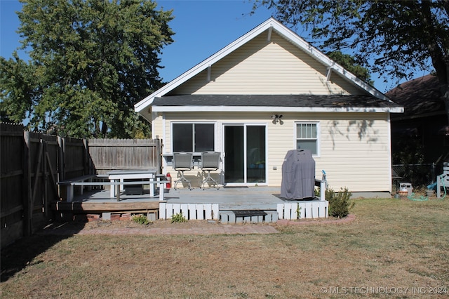 back of house featuring a deck and a lawn