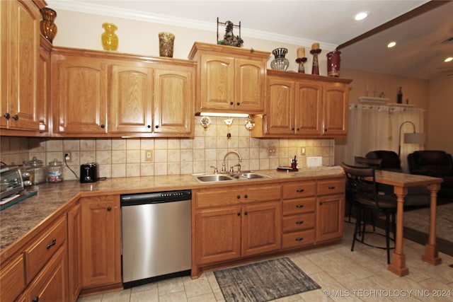 kitchen with ornamental molding, tasteful backsplash, stainless steel dishwasher, and sink