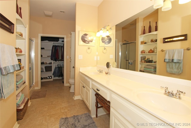 bathroom featuring vanity, a shower with shower door, and toilet