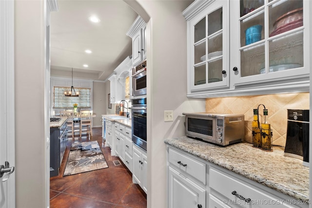 kitchen with white cabinetry, stainless steel oven, and pendant lighting