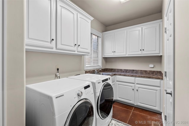 laundry area featuring cabinets, washer and dryer, sink, and dark tile patterned floors