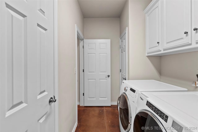 laundry area with washing machine and clothes dryer and cabinets