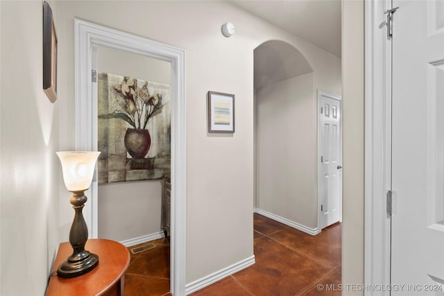 hall featuring dark tile patterned floors