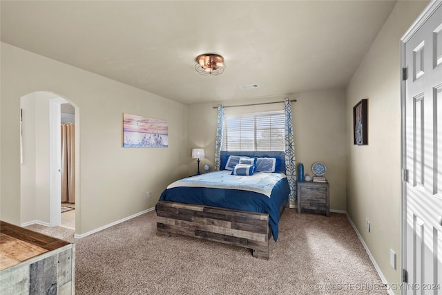 carpeted bedroom featuring ensuite bath