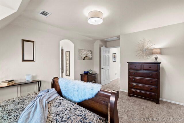 carpeted bedroom with lofted ceiling