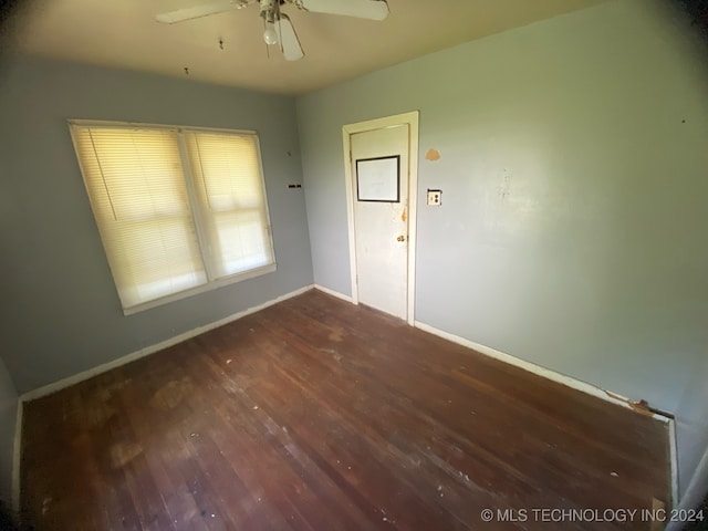 spare room with dark wood-type flooring and ceiling fan