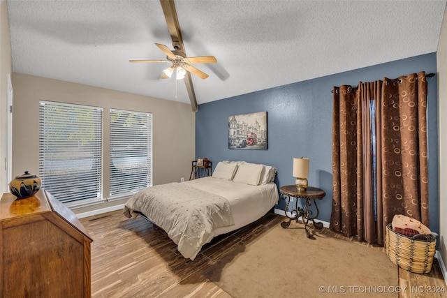 bedroom featuring ceiling fan, light carpet, a textured ceiling, and vaulted ceiling with beams