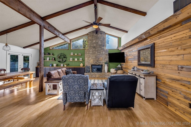 living room featuring wooden walls, lofted ceiling with beams, and light wood-type flooring