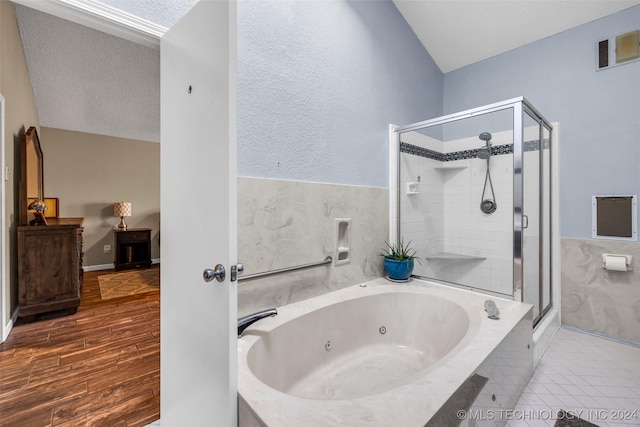 bathroom featuring shower with separate bathtub and a textured ceiling