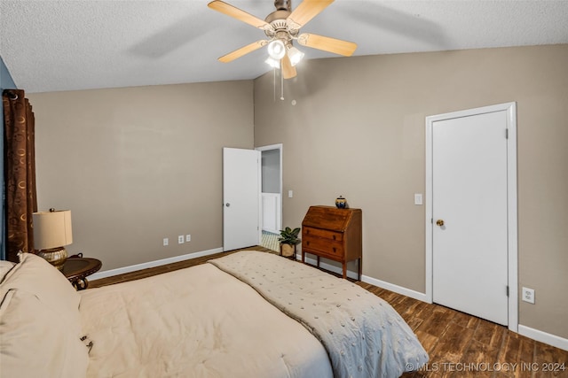 bedroom with lofted ceiling, dark hardwood / wood-style floors, a textured ceiling, and ceiling fan