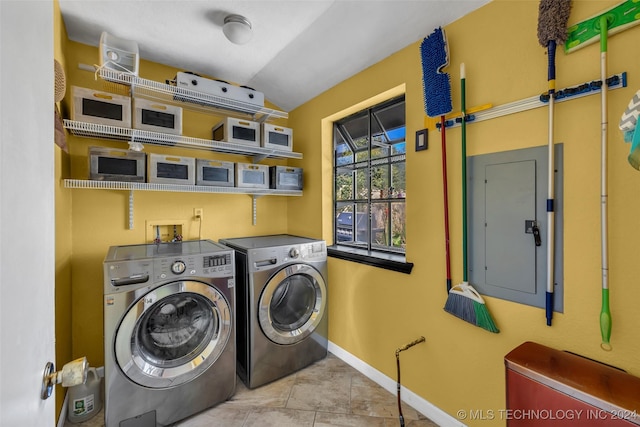 laundry area with electric panel, washer and clothes dryer, and light tile patterned floors