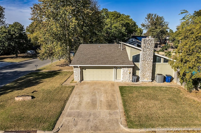 view of front of house featuring a garage, a front yard, and central air condition unit