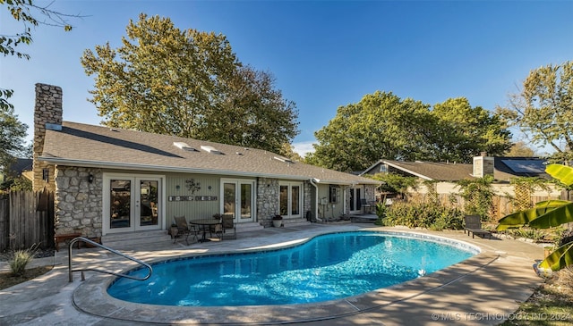 view of swimming pool with a patio and french doors