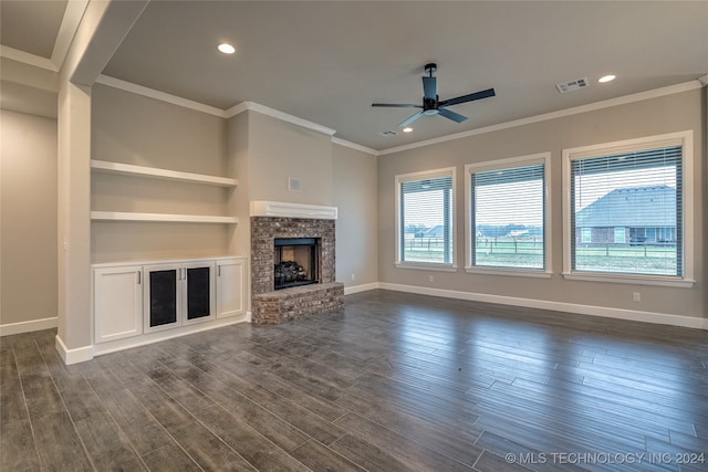 unfurnished living room with ceiling fan, a fireplace, crown molding, and dark hardwood / wood-style floors