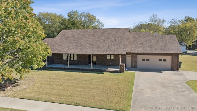 view of front of property featuring a front yard and a garage