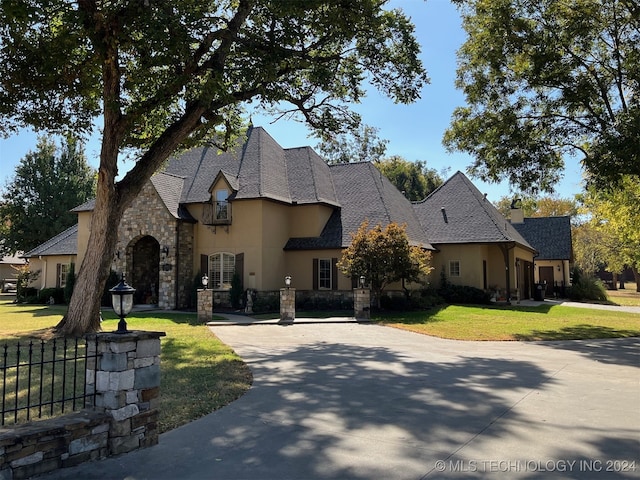 french country inspired facade with a front yard