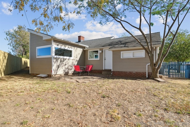 rear view of property featuring a yard and a patio area