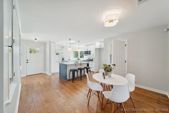 dining space featuring light wood-type flooring and plenty of natural light