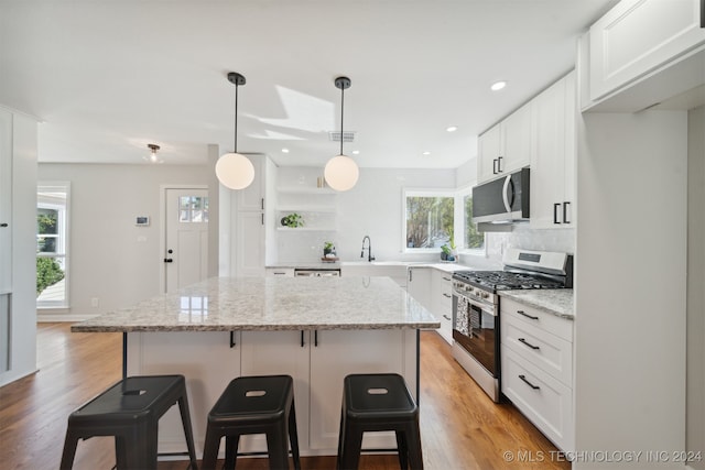 kitchen with white cabinetry, a healthy amount of sunlight, appliances with stainless steel finishes, and a center island