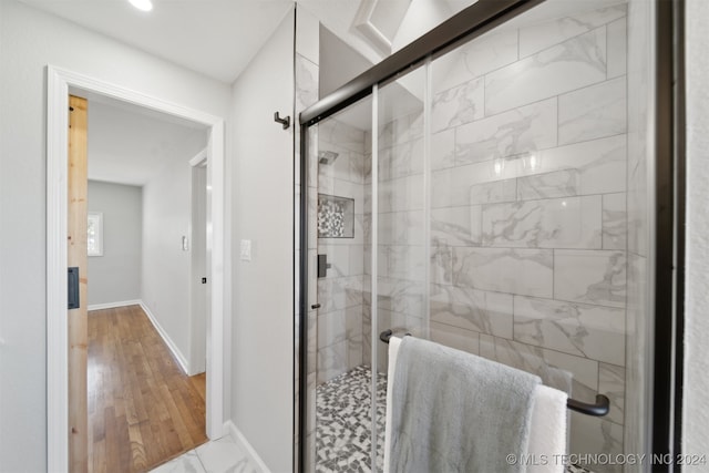 bathroom with hardwood / wood-style flooring and walk in shower