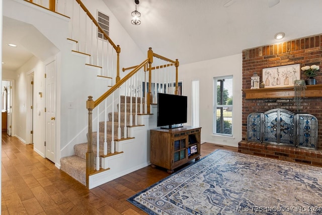 living room featuring a brick fireplace and wood-type flooring