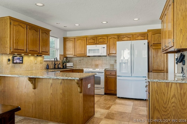 kitchen with sink, white appliances, tasteful backsplash, and kitchen peninsula