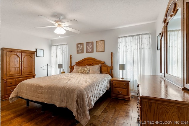 bedroom with a textured ceiling, ceiling fan, and dark hardwood / wood-style floors