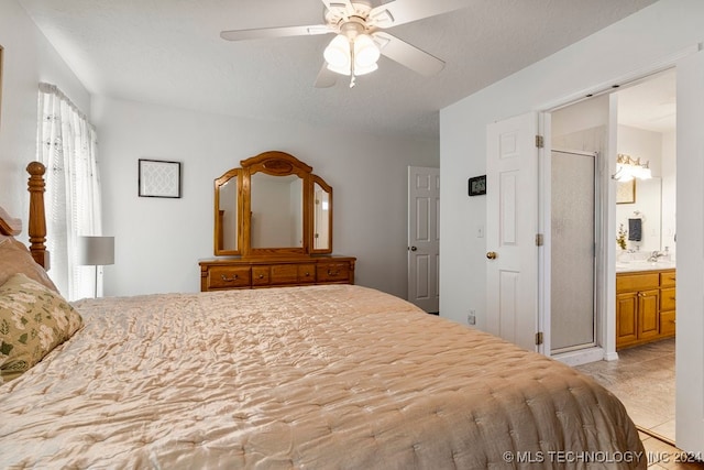 bedroom featuring ensuite bath, light tile patterned flooring, and ceiling fan