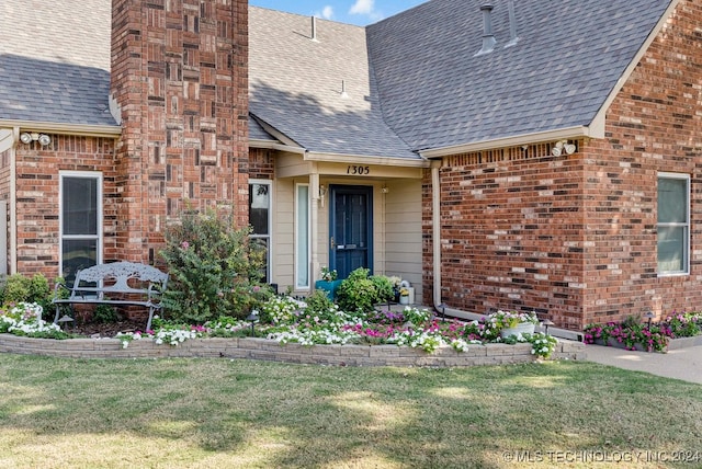 property entrance with a lawn