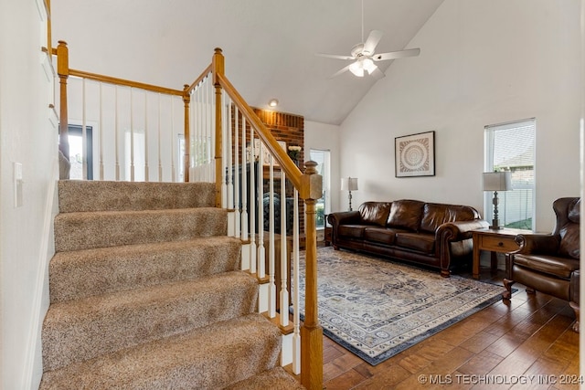 stairway featuring ceiling fan, hardwood / wood-style floors, and high vaulted ceiling