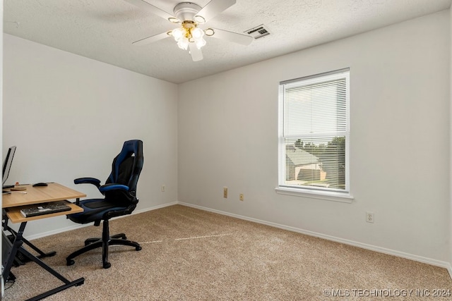 office featuring a textured ceiling, light carpet, and ceiling fan