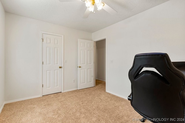 office space with light colored carpet, ceiling fan, and a textured ceiling