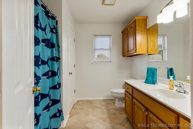 bathroom featuring a healthy amount of sunlight, a shower with shower curtain, vanity, and toilet