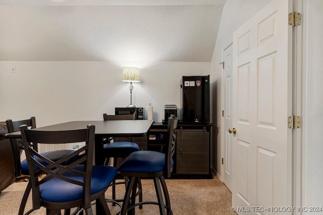 carpeted dining room featuring lofted ceiling