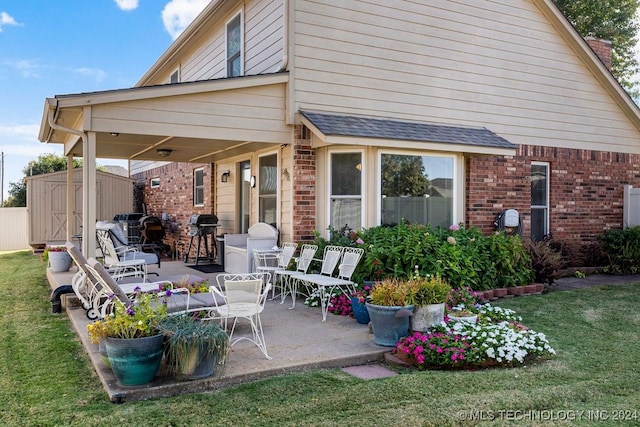 rear view of property featuring a yard, a patio area, and a shed