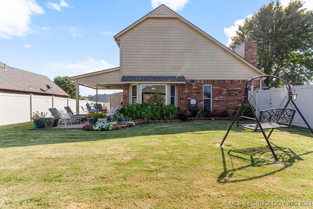 rear view of property with a yard and a patio