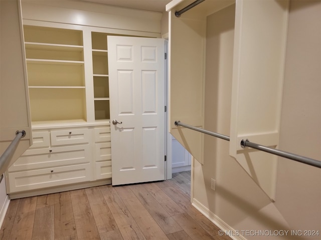 walk in closet with light hardwood / wood-style floors