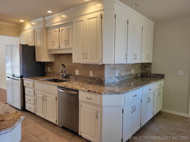 kitchen featuring tasteful backsplash, appliances with stainless steel finishes, sink, white cabinetry, and light stone counters