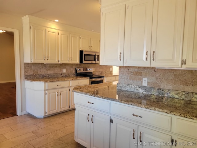 kitchen featuring white cabinets, backsplash, appliances with stainless steel finishes, light hardwood / wood-style floors, and light stone counters