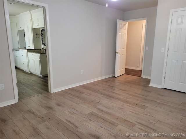 interior space with sink, light hardwood / wood-style floors, and ensuite bath