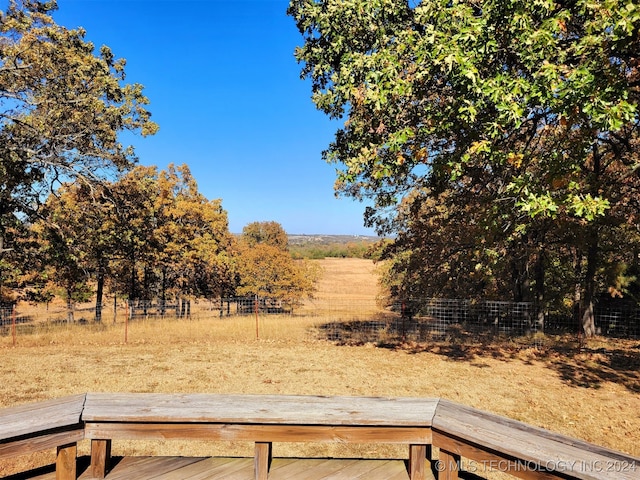 view of yard with a wooden deck and a rural view