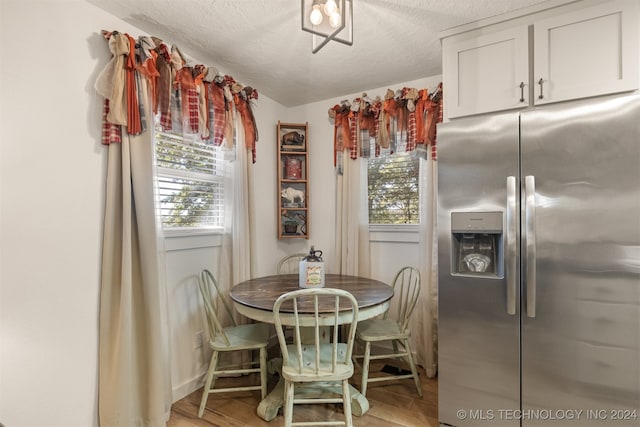 dining room featuring light hardwood / wood-style floors and a textured ceiling