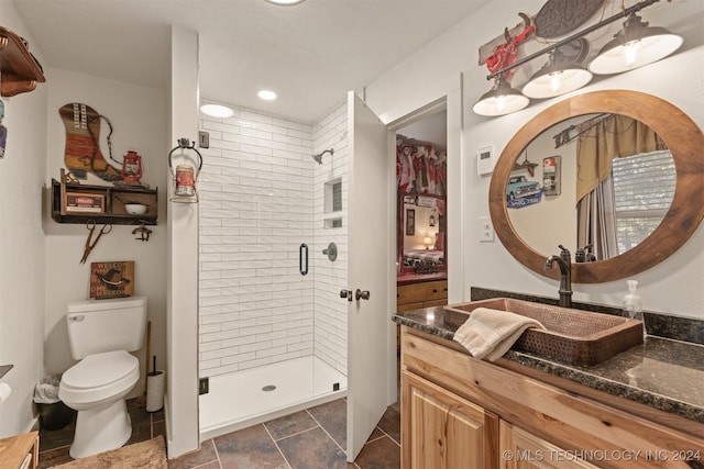 bathroom with vanity, toilet, walk in shower, and tile patterned flooring