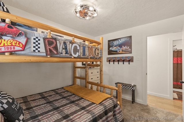 bedroom with hardwood / wood-style floors and a textured ceiling