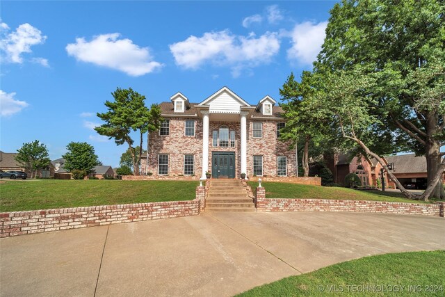 greek revival inspired property featuring a front yard