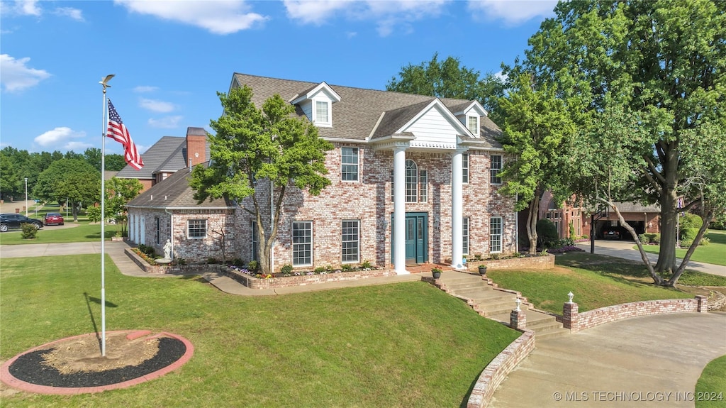 view of front of house featuring a front lawn and brick siding