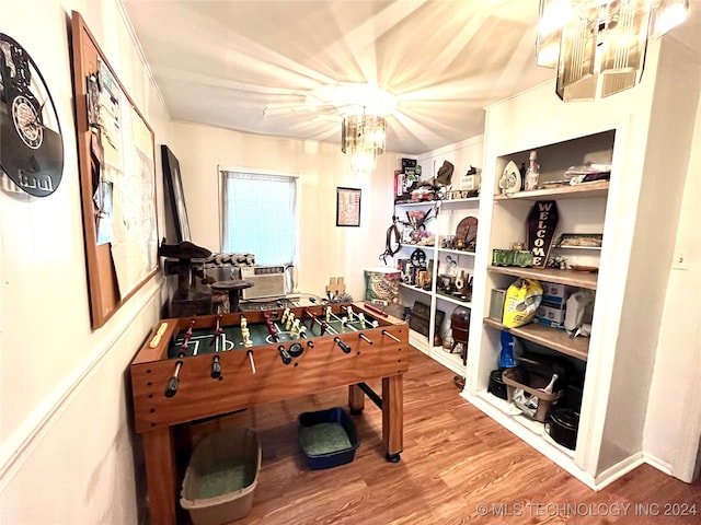 game room featuring a chandelier and hardwood / wood-style flooring