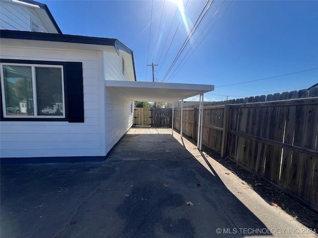 view of side of property featuring a carport and a patio