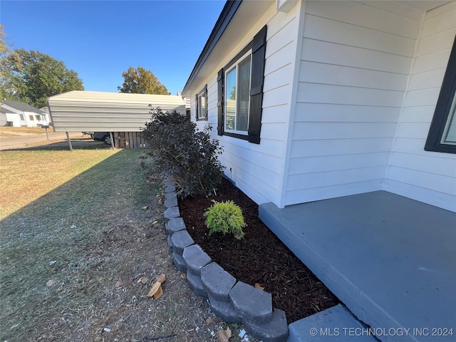 view of side of home featuring a carport and a lawn